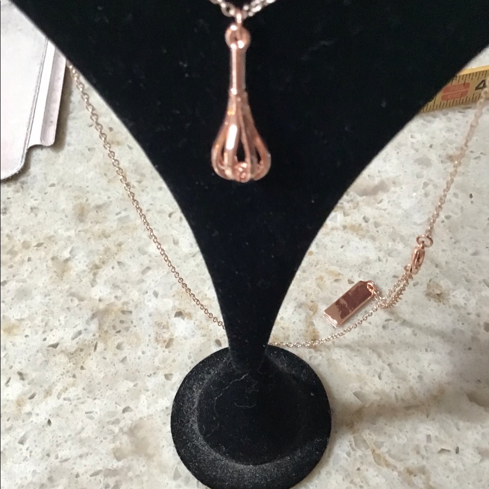 Rose gold whisk necklace.